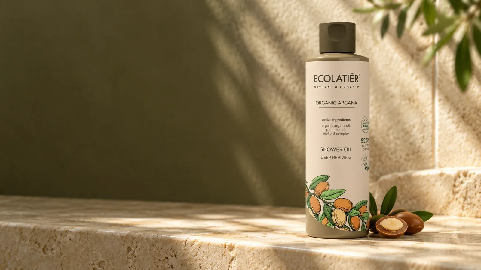 Sprchový olej Ecolatier Organic Argana v pôvodnej fľaši na kamennej poličke