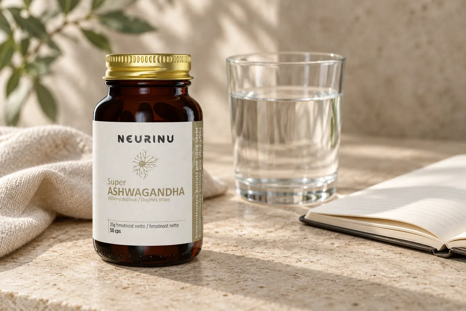 NEURINU Super Ashwagandha v sklenenej fľaštičke pri pohári vody a ľanovej látke