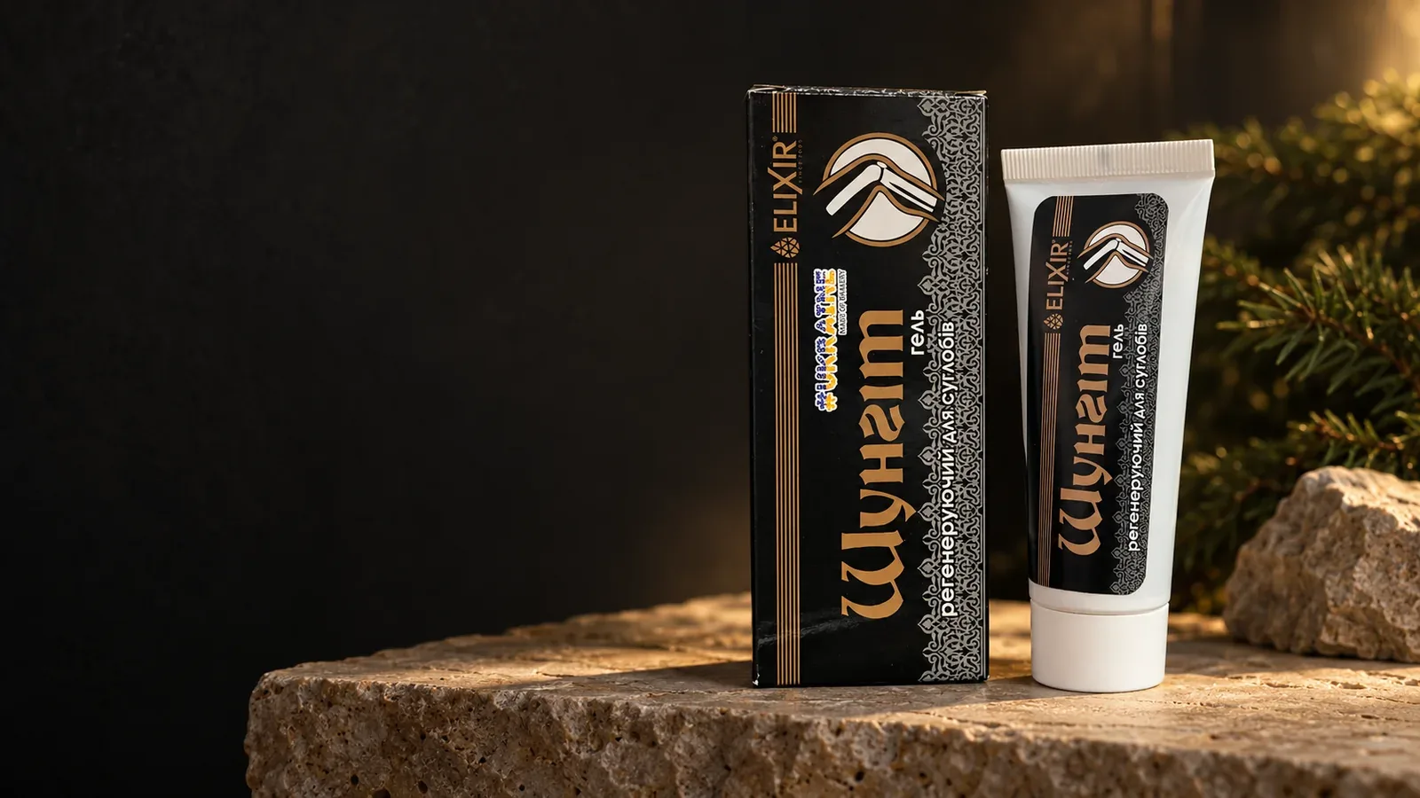 Šungit Elixir v bielej tube s čierno-zlatým obalom na kamennej podložke