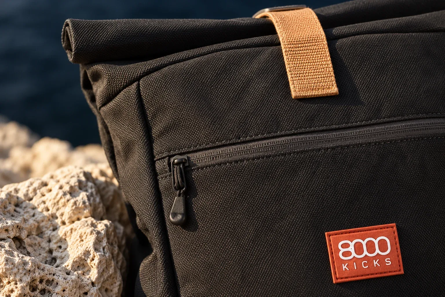 Detail čiernej konopnej tkaniny Everyday Backpack, svetlohnedej časti uzatvárania s logom 8000Kicks a predného zipsu