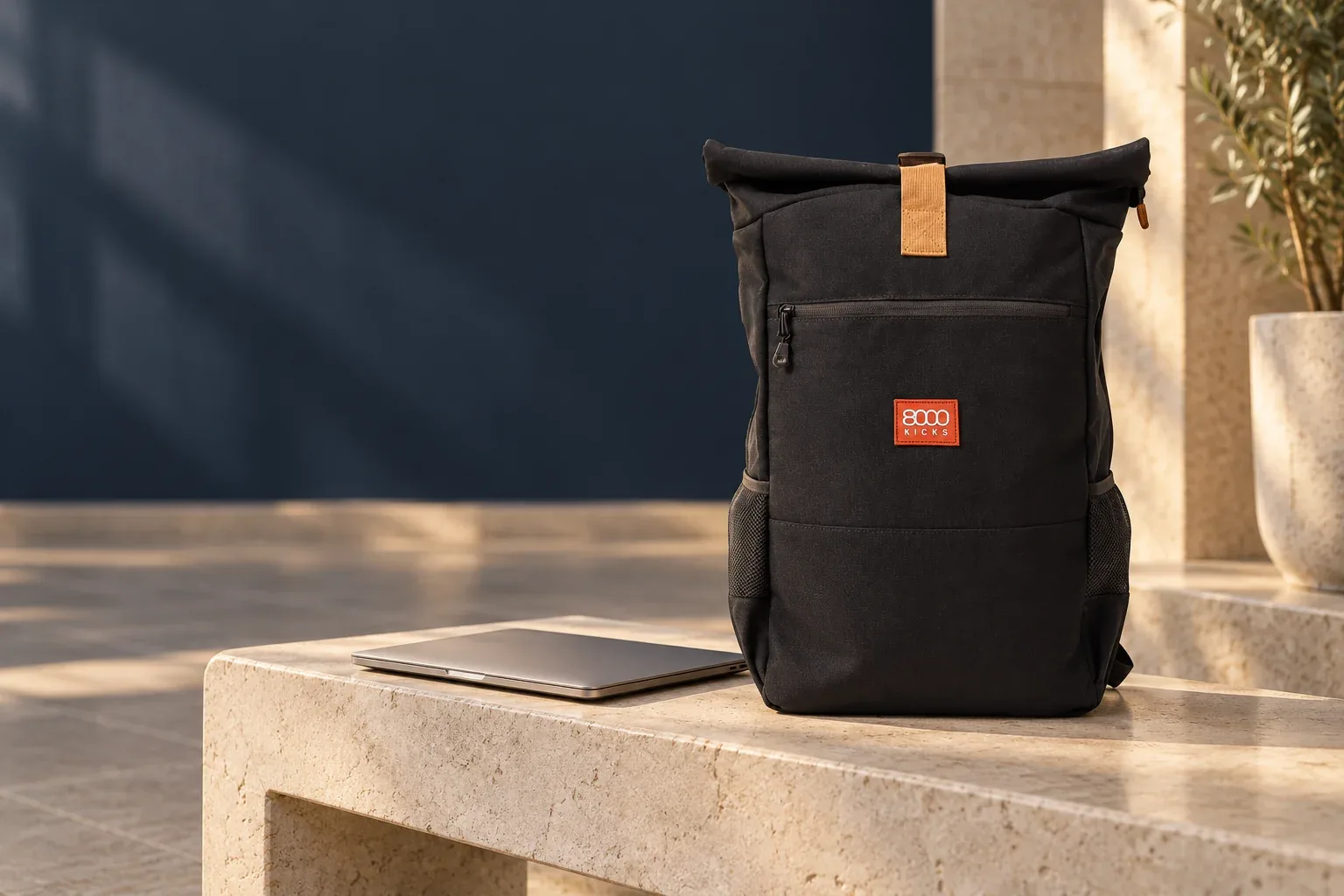 Čierny Everyday Backpack 8000Kicks so svetlohnedou časťou uzatvárania na kamennej lavičke pri zatvorenom notebooku
