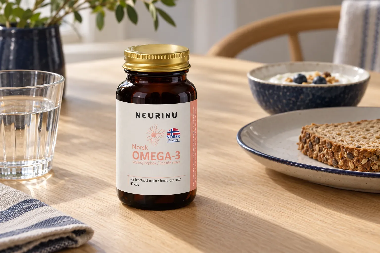 NEURINU Norsk OMEGA-3 na raňajkovom stole pri pohári vody